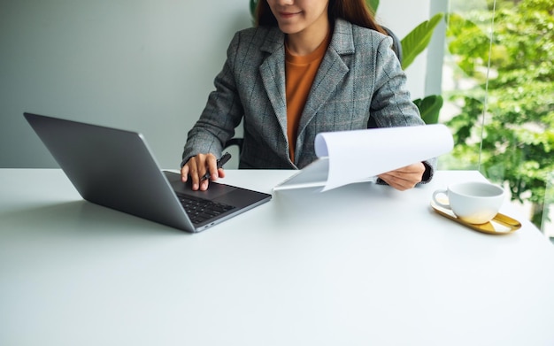 Zbliżenie obrazu bizneswoman korzystającego z laptopa podczas pracy w biurze
