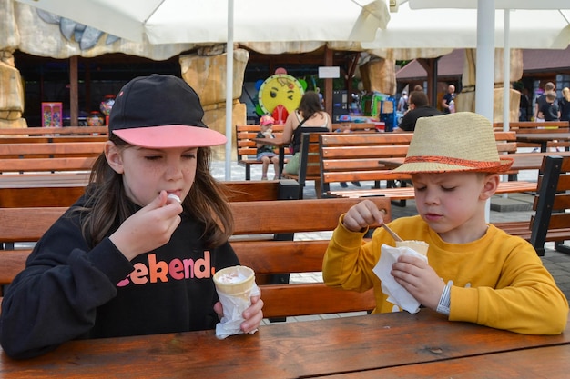 Zbliżenie obrazu chłopca i dziewczynki trzymającej świeży rożek waflowy z lodami waniliowymi i malinowymi na