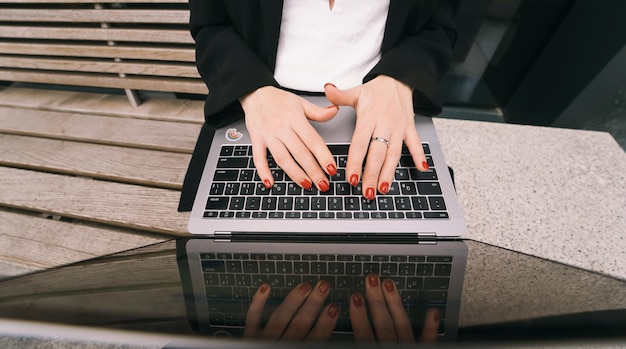 Zbliżenie obrazu dłoni kobiety piszącej na laptopie