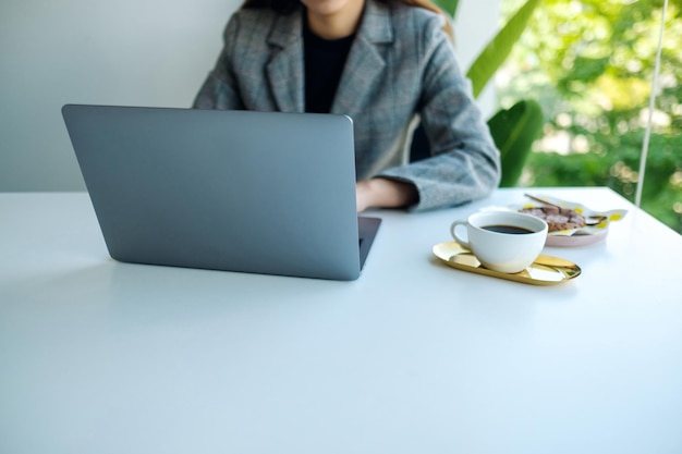 Zbliżenie obrazu kobiety biznesu używającej i pracującej na laptopie w biurze