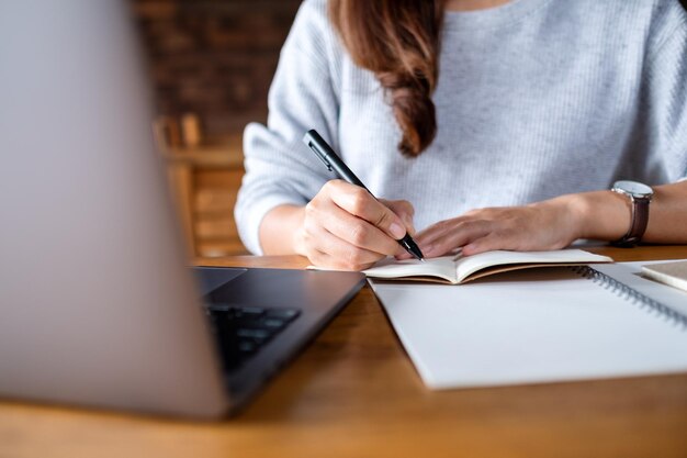 Zbliżenie obrazu kobiety piszącej na notebooku podczas pracy na laptopie