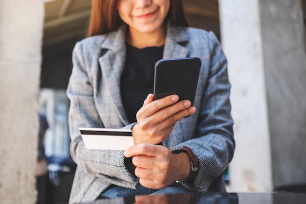 Zbliżenie obrazu kobiety za pomocą karty kredytowej do zakupów i zakupów online na telefonie komórkowym