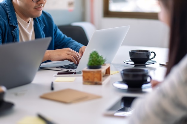 Zbliżenie obrazu osób używających i pracujących na laptopie i tablecie pc na stole w biurze