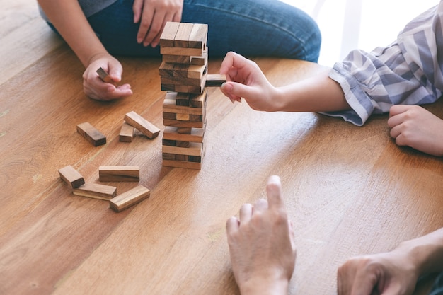 Zbliżenie Obrazu Trzech Przyjaciół Siedzących I Grających Razem W Grę Z Drewnianymi Klockami Tumble Tower