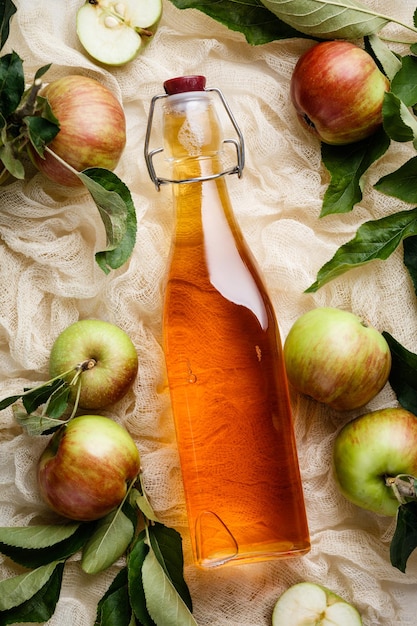 Zdjęcie zbliżenie octu jabłkowego w butelce na tkaninie