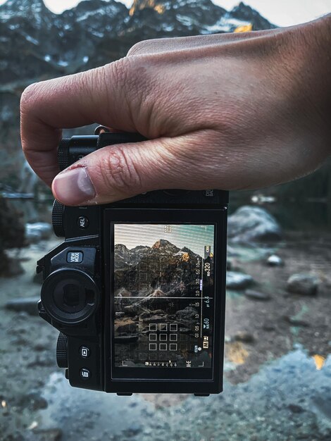 Zdjęcie zbliżenie osoby fotografującej kamerą