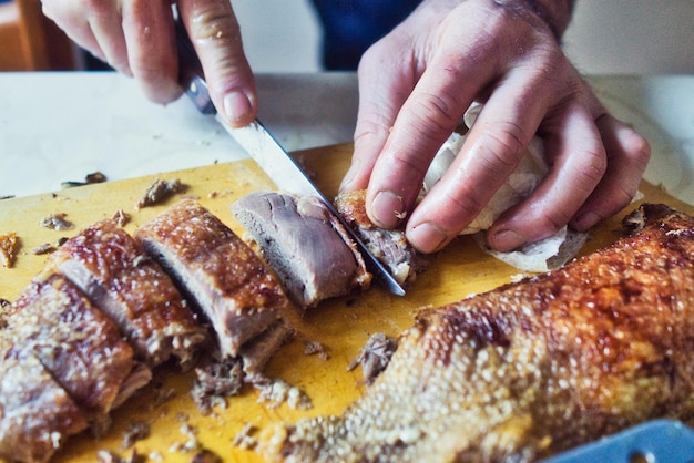 Zdjęcie zbliżenie osoby przygotowującej białe mięso na stole