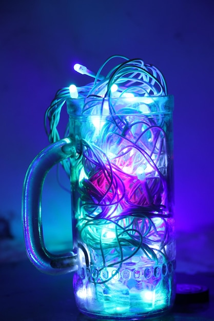 Zdjęcie zbliżenie oświetlonej struny w szklanym kubku
