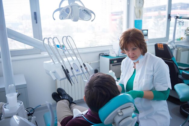 Zbliżenie pacjentki u dentysty czekającej na wizytę kontrolną z lekarzem w tle