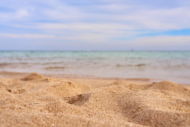 Zbliżenie piasku z rozmytym morzem w tle