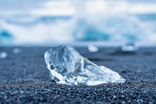 Zbliżenie pięknego kawałka lodu na czarnym piasku na plaży diamentowej