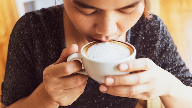 Zbliżenie Pięknej Dziewczyny Pijącej Cappuccino Z Kawą Z Pianki Mlecznej Z Dobrym Samopoczuciem W Kawiarni