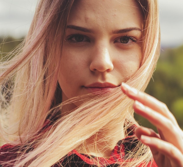Zbliżenie pięknej kobiety z roztrzaskanymi blond włosami