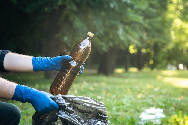 Zbliżenie plastikowej butelki w męskiej dłoni sprzątania natury