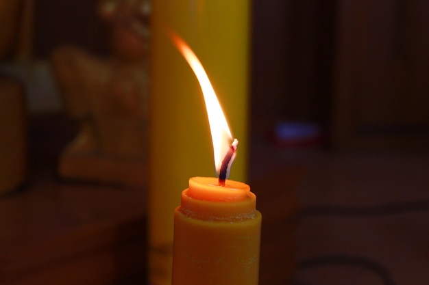 Zdjęcie zbliżenie płonącej świecy w ciemni