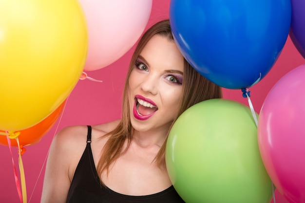 Zbliżenie podekscytowany szczęśliwy uśmiechający się zachwyca glamour młoda kobieta z pinklips z kolorowymi balonami