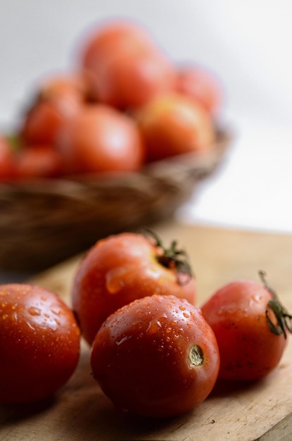 Zdjęcie zbliżenie pomidora wylewanego z pojemnika na deskę do cięcia.