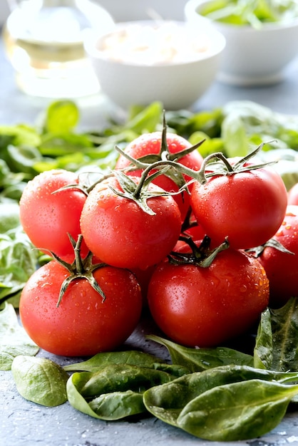 Zdjęcie zbliżenie pomidory w tle warzywnym i liście szpinaku żywność dietetyczna