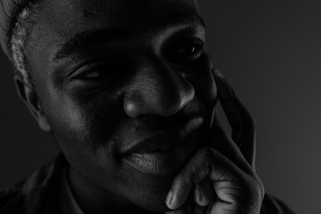 Zbliżenie portret czarny uśmiechnięty Amerykański mężczyzna z dużymi wargami w czarny i biały świetle
