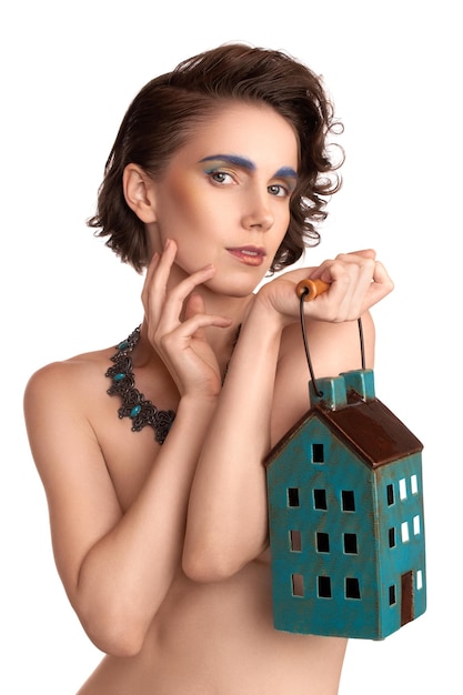 Zbliżenie portret dziewczyna architekt z kolor makijażu trzymając model domu na białym tlexA