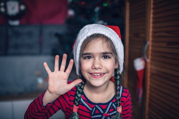 Zbliżenie portret dziewczyny w santa red hat, jakbyśmy widzieli ją na ekranie laptopa odległe wakacje