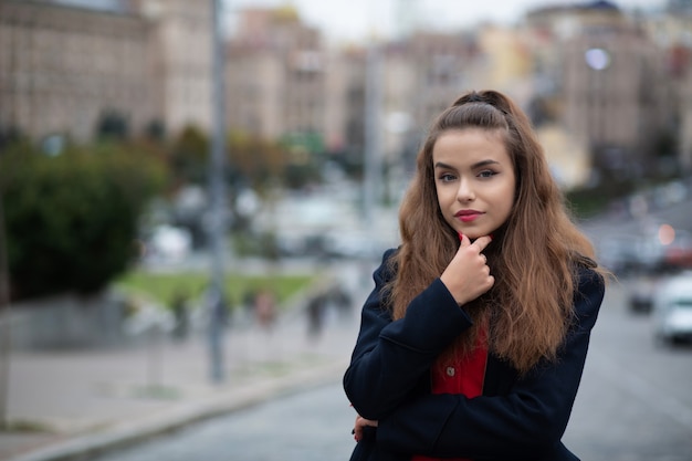 Zbliżenie portret elegancka brunetka kobieta z naturalnym makijażem na sobie niebieski płaszcz. Miejsce na tekst