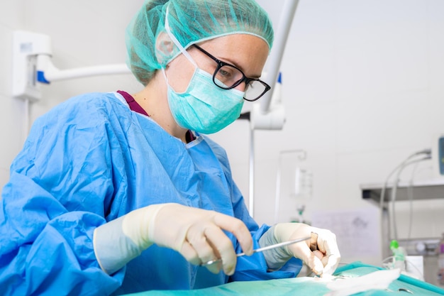 Zbliżenie portret kobiety chirurg nosi sterylne ubrania działające na sali operacyjnej
