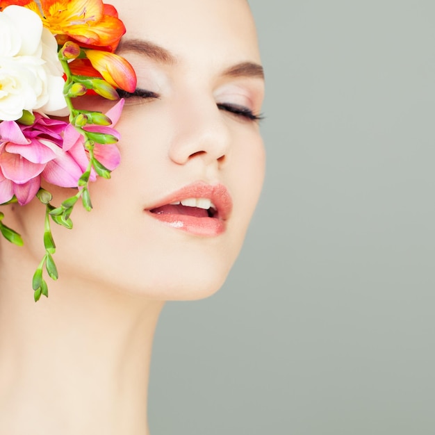 Zbliżenie portret kobiety uzdrowiskowej zdrowej skóry i kwiatów