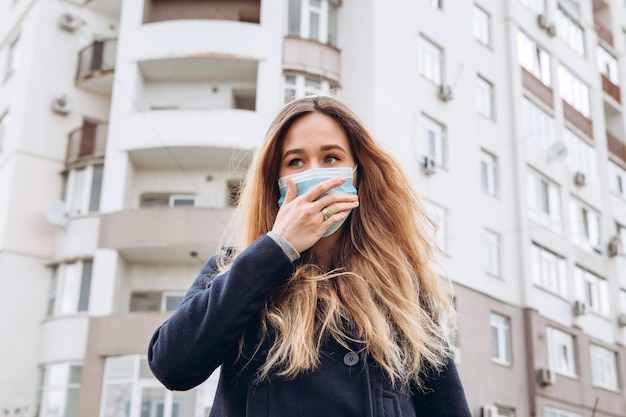 Zbliżenie portret kobiety w medycznej masce na ulicy, epidemia koronawirusa. kobieta naruszyła zasady samoizolacji. SARS-CoV-2. chroń się przed COVID-19.