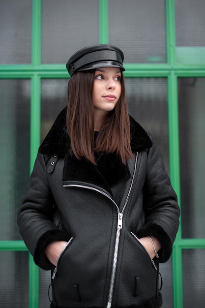 Zbliżenie portret młodej kobiety model nosi czarną czapkę i czarną kurtkę w zimie
