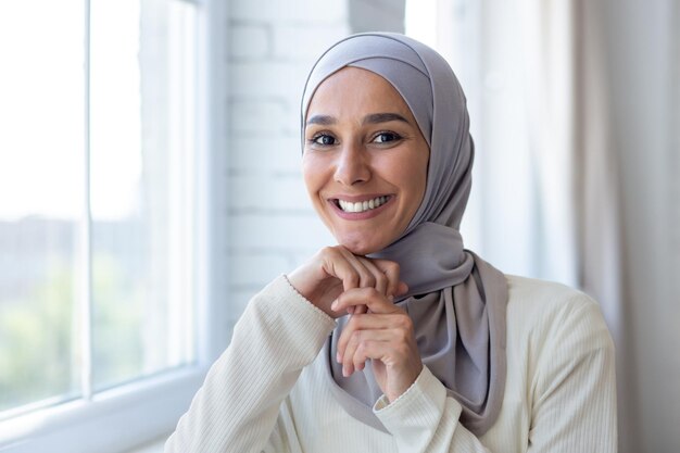 Zbliżenie portret młodej pięknej arabskiej kobiety muzułmanki w hidżabie uśmiechając się i patrząc na kamery