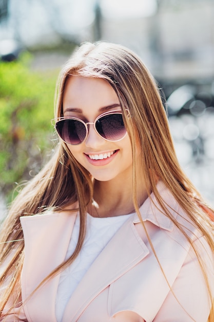 Zbliżenie portret młodej pięknej kobiety modne z okulary przeciwsłoneczne. Lady posing outdoor