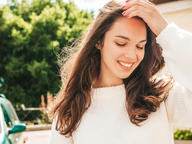 Zbliżenie portret piękny uśmiechający się model brunetka. Modna kobieta pozuje na ulicy