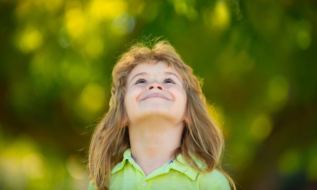 Zbliżenie portret słodkiego chłopca patrzącego na zewnątrz Zbliżenie headshot portret uśmiechniętego małego chłopca na tle przyrody szczęśliwe małe dziecko w wieku przedszkolnym
