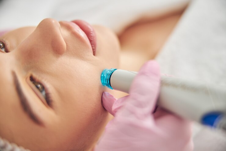 Zbliżenie portret spokojnej pacjentki leczonej przez dermatologa przy użyciu sprzętowej kosmetologii