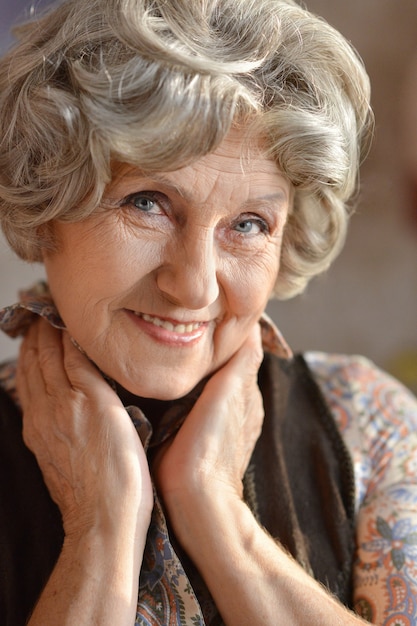 Zbliżenie portret szczęśliwej starszej kobiety w domu