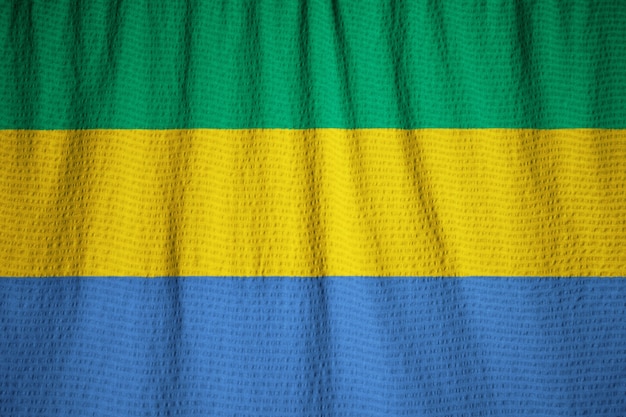 Zbliżenie potargane flaga Gabonu, Gabon flaga wiejący wiatr