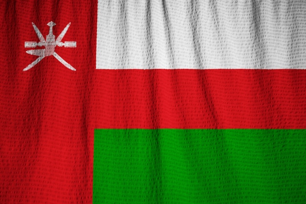 Zbliżenie potargane flagi Oman, flaga Oman wiejący wiatr