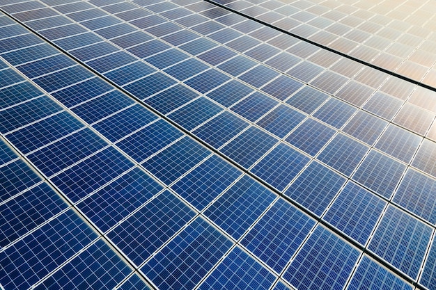 Zbliżenie powierzchni niebieskich fotowoltaicznych paneli słonecznych zamontowanych na dachu budynku do produkcji czystej ekologicznej energii elektrycznej. Produkcja koncepcji energii odnawialnej.