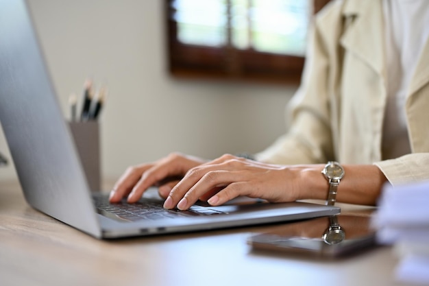 Zbliżenie Profesjonalna Azjatycka bizneswoman pracująca przy biurku przy użyciu laptopa