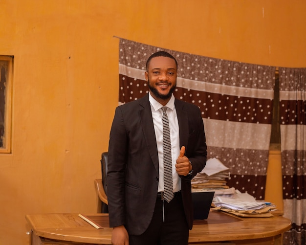 Zbliżenie przystojnego afrykańskiego biznesmena w biurze uśmiechnięty