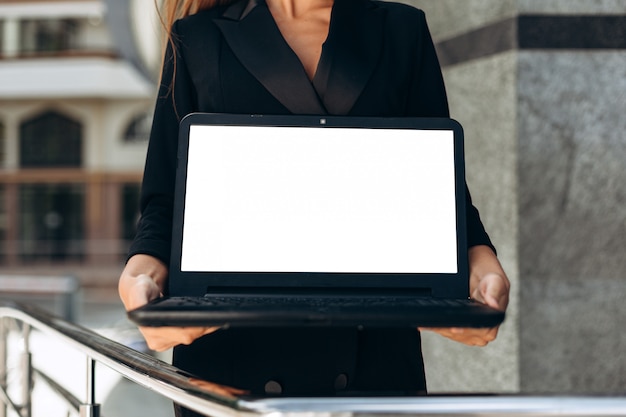 Zdjęcie zbliżenie pusty makieta biały ekran laptopa w rękach kobiet. - obraz