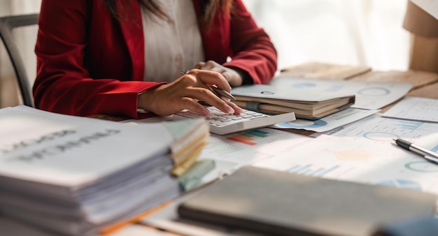 Zbliżenie rąk bizneswomanu za pomocą kalkulatora do sprawdzania finansów i zarobków firmy oraz budżetu Biznesmenka obliczająca miesięczne wydatki zarządzająca dokumentami budżetowymi dokumenty pożyczkowe faktury