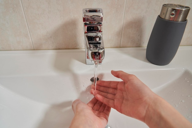 Zbliżenie rąk dziewczyny myjącej je w łazience