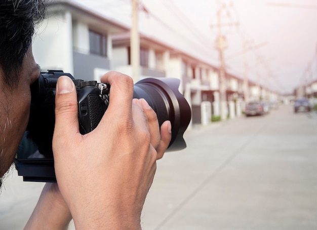 Zbliżenie rąk młodego azjatyckiego fotografa robiącego zdjęcia osiedli mieszkaniowych