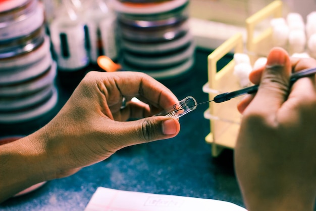 Zdjęcie zbliżenie rąk osób eksperymentujących w laboratorium