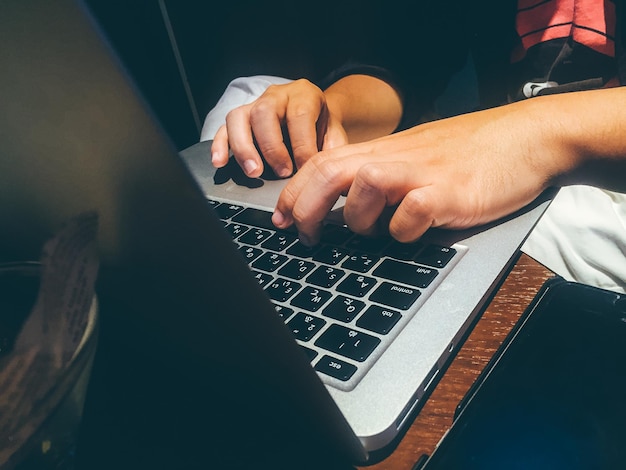Zbliżenie rąk za pomocą klawiatury laptopa