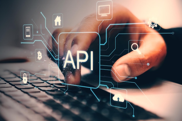 Zbliżenie ręcznego pisania na klawiaturze z neonowymi ikonami API i symbolami technologicznymi na tle ekranu