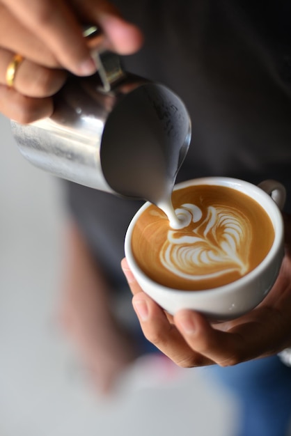 Zbliżenie ręcznego przygotowywania latte