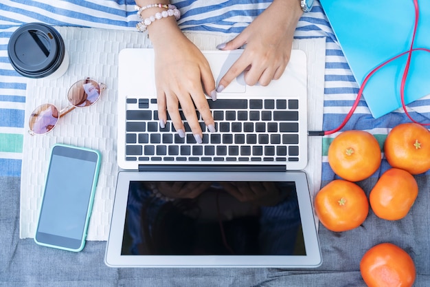 Zbliżenie Ręka Używać Laptop Z Wiszącą Ozdobą I Akcesoriami Na Stole.